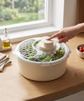 Straight Up Game Changer Electric Salad Spinner With Rapid Drain Tech That Cuts Water From Greens In Seconds in use on wooden countertop.