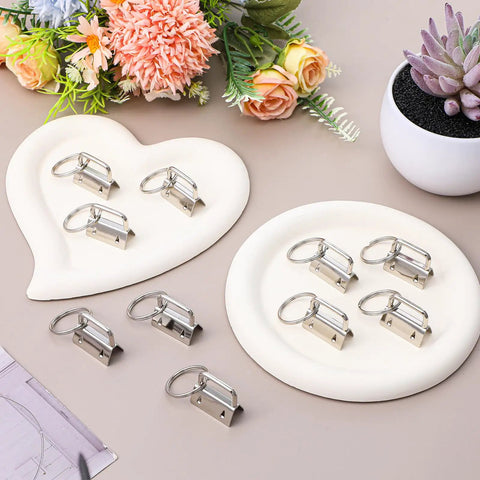 Top Shelf One Inch Silver Key Fob Hardware Bulk Pack With Smooth Split Rings And Heavy Duty Wristlet Clasps on white plates.