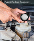 Close-up of hands holding Brake Master Cylinder Fluid Reservoir Cap Replacement 47230 47090 For Toyota Avalon in engine bay