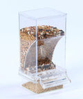 Top Tier No Mess Bird Feeder Set That Keeps The Cage Crisp Includes Cozy Perch And Crystal Clear Acrylic Hopper filled with bird seed.