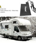 Heavy Duty Silicone Battery Heater Pad With Auto Thermostat Control Keeps Your Ride Kickstarting Fast In Brutal Winter Chill For Smooth Cold Morning Starts At One Twenty Volt Sixty Watt Grey with warning sign, next to snow-covered camper.