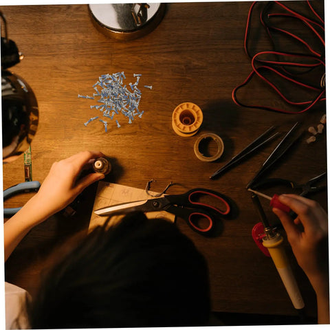 Glasses Repair Screws Kit, 100 Piece Eyeglass Screw Set For Glasses And Sunglasses on a workbench with tools and wires