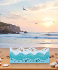 Beach Wave Metal Cutting Dies Set For Scrapbooking And Card Making on a sandy beach with ocean background, summer art supplies