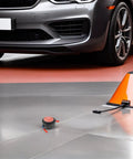 Badass Two Pack Aerosol Self Activating Auto Fire Extinguisher Sticker With Sticky Adhesive Backing For Car Engine Garage Or Rig That Takes Care Of Smoke Quick on garage floor near orange cone.
