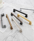 Assorted colored cabinet pulls on a marble surface, showcasing design and color variety, similar in size to 10 Pack 5 Inch Cabinet Pulls In Oil Rubbed Bronze For Kitchen Cabinets Cupboards Dresser Drawers Bedroom Wardrobes And Bathroom Furniture Hardware Solid Metal Handles With Smooth Rounded Edges For Easy Use And Elegant Finish.