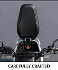 Motorcycle seat with a black cushion and handlebar view, showcasing red stitching details and careful craftsmanship.