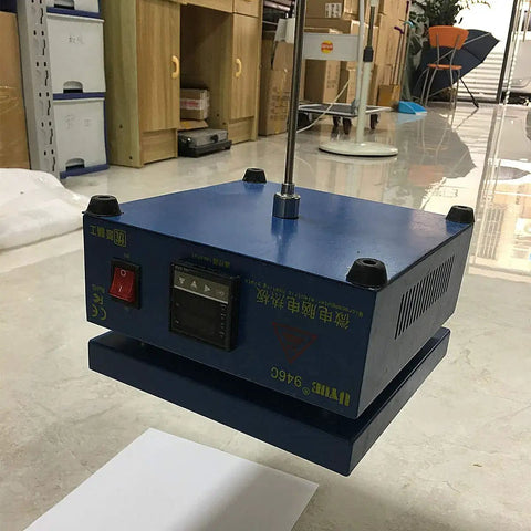 Blue electronic device on floor, focus unclear, possibly workshop setting, various office items in background.