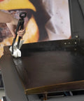 Hand using tongs with cloth to apply Griddle Seasoning And Cast Iron Conditioner 2 In 1 Formula For Nonstick Release And Rust Protection