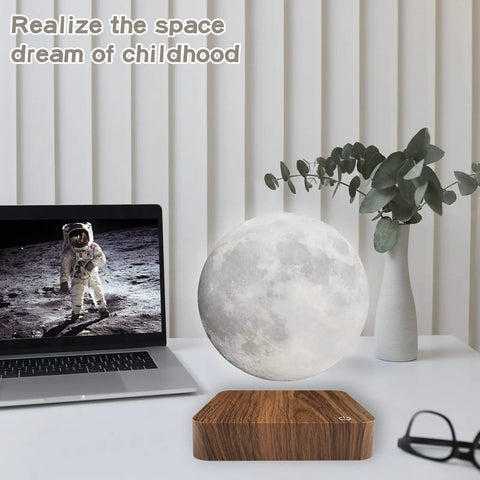 Levitating Moon Lamp With Magnetic Floating Spin next to laptop and vase in home office setup