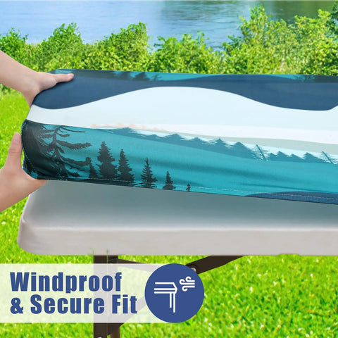 Person fitting a Picnic Table Cover Set With Two Bench Covers For 6 Foot Tables Elastic Spandex Stretch Fit Washable Outdoor Patio Dining Protector Forest Green 72 Inch Table Cover And 72 Inch By 12 Inch Bench Covers securely on a patio table near a scenic view of trees and water.