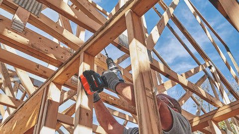 Worker using PROFACTOR 18V Connected Ready Half Inch Hammer Drill and Driver Bare Tool Built to Crush Tough Jobs With Onboard UI Leveling Angle Control And App Connectivity For Custom Settings Via Toolbox App in wood framing