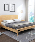 Modern bedroom with wooden bed frame, gray bedding, and decorative pillows in a well-lit room with large windows and wall art.
