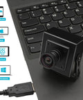 1080P 120FPS High Speed USB Camera With M12 Wide Angle 12MP IMX577 Sensor Lightburn Compatible External Computer Camera next to laptop keyboard