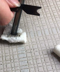 Using a ferro rod and flint striker to ignite a waterproof tinder tab, part of the 48 Pack Fire Starter Tabs Waterproof Tinder For Camping.