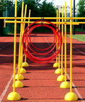 Drone Racing Obstacle Course Kit For Indoor And Outdoor Use with yellow poles and red hoops on a track