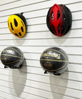 Sports helmets and basketballs mounted on a white slatwall in a garage, showcasing Beefy Power Tool Slatwall Organizer Kit features.