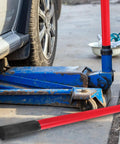 Heavy Duty Red Floor Jack Handle Extension And Jacking Pole Lever With Slick Coating For Quick Setup And Easy Pumps next to a blue jack.