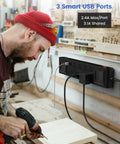 Man using drill near Heavy Duty 11 In 1 Power Strip With 8 Outlets And 3 USB Ports, 2 Worklights, 6.5-ft extension in workshop