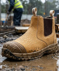 Mens 6 Inch Steel Toe Slip On Work Boots Chelsea Waterproof Safety Footwear Heavy Duty in muddy wet conditions with droplets.