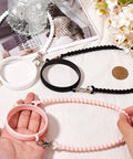 3 Pack Water Bottle Handle Straps Set in Pink White Black, Soft Silicone Sling Carriers for Walking and Hiking displayed on table