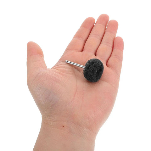 Hand holding a single piece from the 40 Piece Abrasive Buffing Wheel Set For Drill With Fiber And Alloy High Efficiency Polishing Wheels