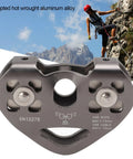 Backyard Zipline Pulley System With Rotating Double Trolley Lightweight Forged Aluminum Alloy Smooth Stainless Steel Wheel Dual Cable Rail Trolley For Epic Outdoor Adventure in front of mountains with climber