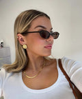 Woman wearing Retro Oval Sunglasses For Women With Cat Eye 90s Vibe Lightweight Narrow Frames UV Protection Sun Glasses.
