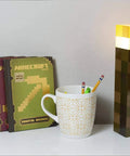 Brownstone Torch Lamp 11.5 Inch LED Night Light With USB Charging Port; wall-mount torch next to books and mug on desk