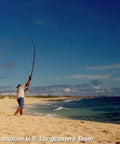 Angler casting rod on sandy beach, preparing for saltwater fishing with Marine Grade Reel Oil And Grease Kit With Precision Applicators.