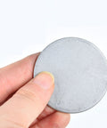 Hand holding 304 Stainless Steel Disc Blanks For DIY Jewelry Making And Metal Craft Projects 20 To 28 Mm Diameter 1.2 Mm Thick