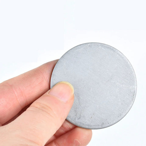 Hand holding 304 Stainless Steel Disc Blanks For DIY Jewelry Making And Metal Craft Projects 20 To 28 Mm Diameter 1.2 Mm Thick