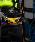 Technician holding a Data And Coax Cable Stripping Tool With Radial Design for RG59 RG6 and CAT3 to CAT6A in a tool belt pocket.