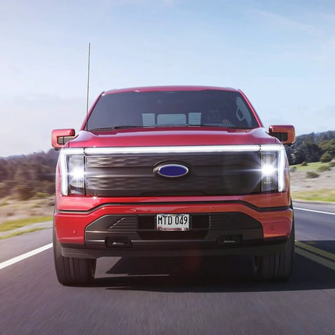 Red truck driving on highway with Faithful Black Chrome License Plate Frame For 49ers Fans Officially Licensed Team Metal Frame attached.