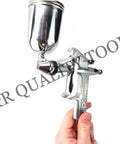Slick Compact Spray Gun Airbrush Kit With A Hella Precise 0.5mm Nozzle and Ergonomic Trigger in hand, silver metal finish.