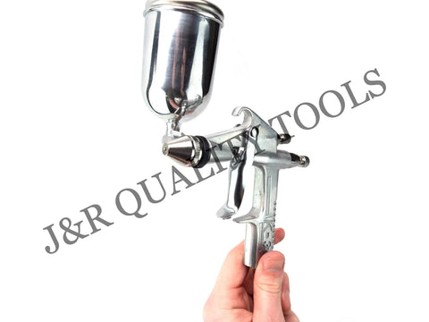Slick Compact Spray Gun Airbrush Kit With A Hella Precise 0.5mm Nozzle and Ergonomic Trigger in hand, silver metal finish.