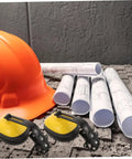 Job Site Tough Safety Hard Hat Ear Muffs With Integrated Noise Blocking Cups For Industrial Hearing Protection And Heavy Duty Construction Environments with orange hard hat and blueprints.