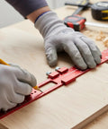 Woodworker using a red Woodworking Ruler With Adjustable Guide And 45 Degree Reference on a wooden board for precision marking.