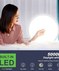 Woman in a room admiring Ultra Slim 12 Inch LED Flush Mount Ceiling Light, 5000K Daylight White, glowing on bed.