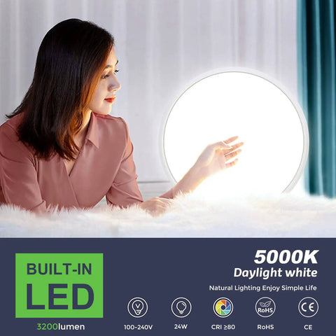 Woman in a room admiring Ultra Slim 12 Inch LED Flush Mount Ceiling Light, 5000K Daylight White, glowing on bed.