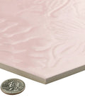 Corner view of hex rose porcelain tile with textured soft pink glaze next to a coin, 8.6 by 9.9 inches, Gaudi Lux style