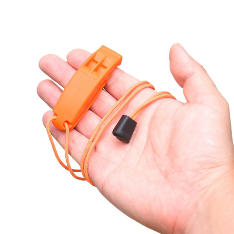Hand holding orange whistle with lanyard from 2X Survival Whistles With Lanyards And 2X Reflective Signal Mirrors, Grab-And-Go Rescue Kit.