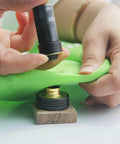 Using Solid Brass Grommet Kit With Three Eighths And One Half Inch Grommets Eyelets Setting Tool And Storage Box NH1003K on green fabric