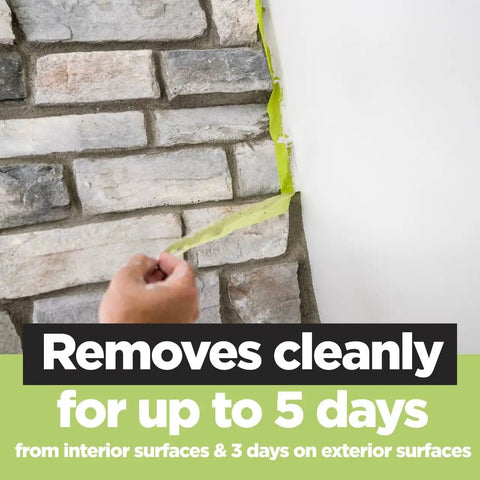 Person peeling Rough Surface Extra Strength Painter's Tape 0.94 Inch By 60.1 Yard off brick wall, showing clean removal.