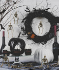 Six Pack Five Point Nine Inch Poseable Mini Skeleton Figurines in Halloween decor with wreath and pumpkins