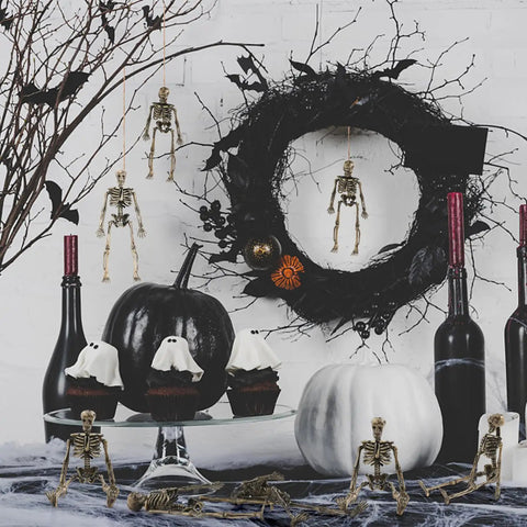 Six Pack Five Point Nine Inch Poseable Mini Skeleton Figurines in Halloween decor with wreath and pumpkins
