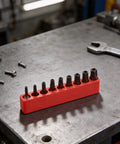 Awesome 8-Piece Torx Security Bit Set With Hardened Steel TS8 To TS40 Sizes For Power Drills Auto And Electronics Repair At 1-Inch Length To Handle Heavy Duty Jobs Without Slipping Or Stripping Threads., red holder with eight Torx security bits on workbench