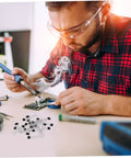 Man soldering on a circuit board with smoke, using Built Tough 20 Piece Hall Effect Sensor Kit With Bipolar Latching Linear Sensor.