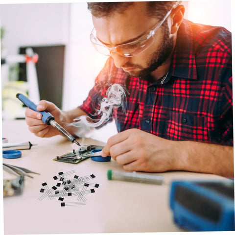 Man soldering on a circuit board with smoke, using Built Tough 20 Piece Hall Effect Sensor Kit With Bipolar Latching Linear Sensor.