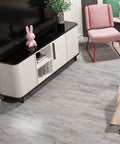 Living room with 32 Pack Peel And Stick Vinyl Floor Tiles 12x12 Inch Waterproof Removable Sheet Flooring For Kitchen Bathroom Basement Retro Laminate Look Easy Self Adhesive Install Renters Friendly featuring grey tones next to a modern TV stand and chair.