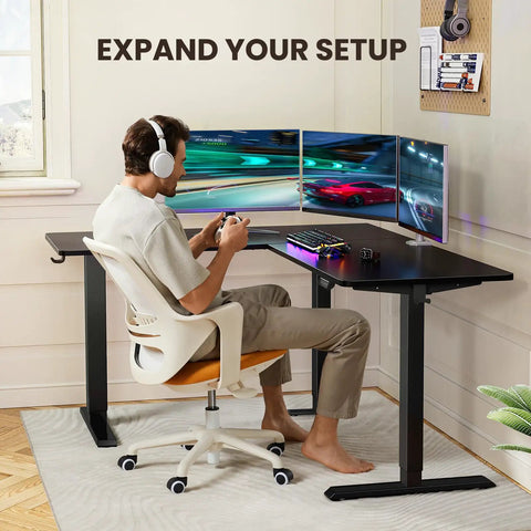 Person using L Shaped Standing Desk 63 By 55 Inches Electric Sit Stand Table With Adjustable Height, gaming setup, black.